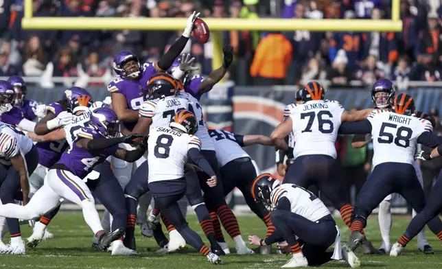 Minnesota Vikings defensive tackle Jerry Tillery, top center, blocks a field goal attempt by Chicago Bears place kicker Cairo Santos during the first half of an NFL football game Sunday, Nov. 24, 2024, in Chicago. (AP Photo/Charles Rex Arbogast)