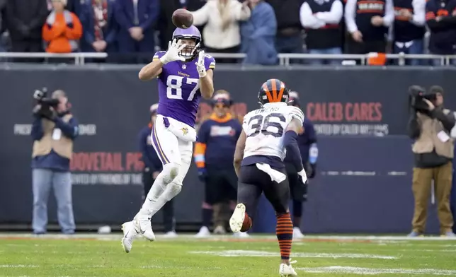 Minnesota Vikings tight end T.J. Hockenson (87) makes a catch past Chicago Bears safety Jonathan Owens (36) during overtime of an NFL football game Sunday, Nov. 24, 2024, in Chicago. (AP Photo/Charles Rex Arbogast)