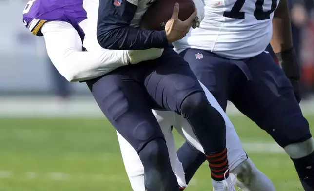 Chicago Bears quarterback Caleb Williams is sacked by Minnesota Vikings linebacker Jonathan Greenard (58) during the first half of an NFL football game Sunday, Nov. 24, 2024, in Chicago. (AP Photo/Charles Rex Arbogast)