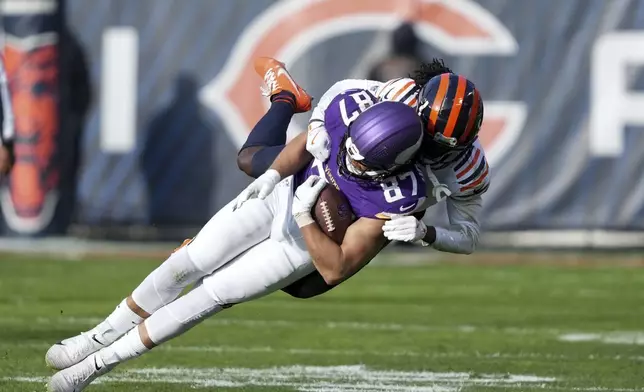 Minnesota Vikings tight end T.J. Hockenson (87) is tackled by Chicago Bears cornerback Terell Smith after a catch during the first half of an NFL football game Sunday, Nov. 24, 2024, in Chicago. (AP Photo/Charles Rex Arbogast)