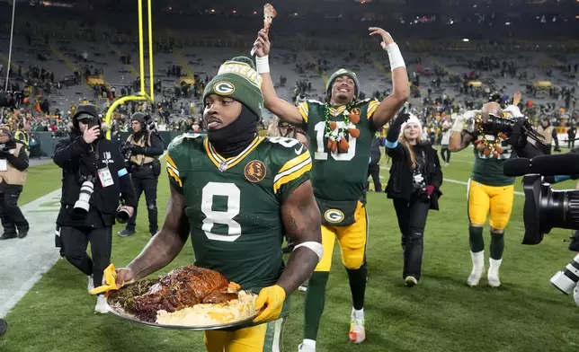 Green Bay Packers running back Josh Jacobs (8) and quarterback Jordan Love (10) walk off the field after an NFL football game against the Miami Dolphins Thursday, Nov. 28, 2024, in Green Bay, Wis. (AP Photo/Morry Gash)