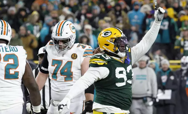 Green Bay Packers defensive tackle T.J. Slaton (93) celebrates in front of Miami Dolphins offensive tackle Liam Eichenberg (74) after a defensive stop during the second half of an NFL football game Thursday, Nov. 28, 2024, in Green Bay, Wis. (AP Photo/Mike Roemer)