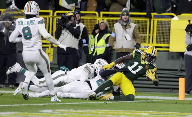 Green Bay Packers wide receiver Jayden Reed catches a 12-yard touchdown pass during the first half of an NFL football game against the Miami Dolphins Thursday, Nov. 28, 2024, in Green Bay, Wis. (AP Photo/Matt Ludtke)