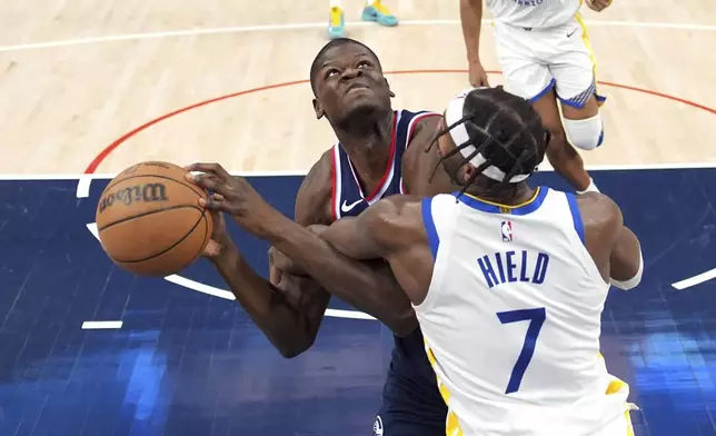 Los Angeles Clippers center Mo Bamba, left, is fouled by Golden State Warriors guard Buddy Hield as he tries to shoot during the second half of an NBA basketball game, Monday, Nov. 18, 2024, in Inglewood, Calif. (AP Photo/Mark J. Terrill)