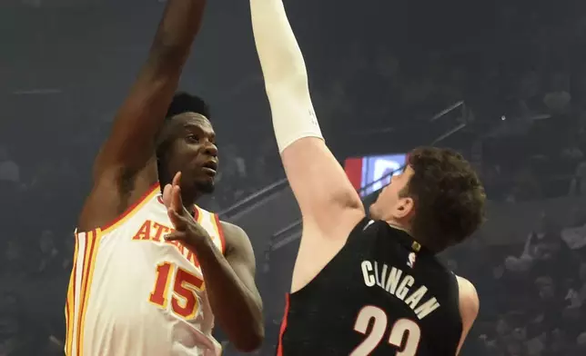 Atlanta Hawks center Clint Capela, left, shoots the ball over Portland Trail Blazers center Donovan Clingan, right, during the first half of an NBA basketball game in Portland, Ore., Sunday, Nov. 17, 2024. (AP Photo/Steve Dykes)