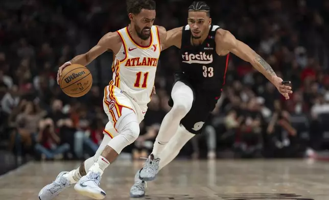 Atlanta Hawks guard Trae Young (11) drives to the basket as Portland Trail Blazers forward Toumani Camara (33) defends during the first half of an NBA basketball game Sunday, Nov. 17, 2024, in Portland, Ore. (AP Photo/Jenny Kane)