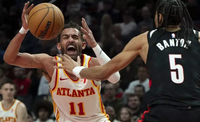 Atlanta Hawks guard Trae Young (11) is fouled as Portland Trail Blazers guard Dalano Banton (5) defends during the first half of an NBA basketball game Sunday, Nov. 17, 2024, in Portland, Ore. (AP Photo/Jenny Kane)