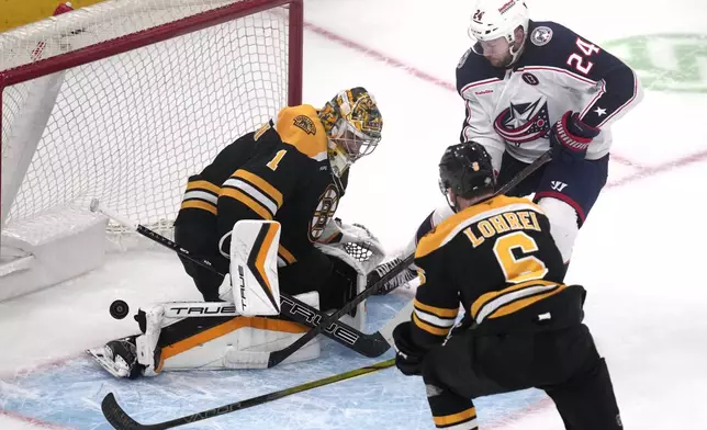 Columbus Blue Jackets right wing Mathieu Olivier (24) pokes the puck past Boston Bruins goaltender Jeremy Swayman (1) during the first period of an NHL hockey game, Monday, Nov. 18, 2024, in Boston. (AP Photo/Charles Krupa)