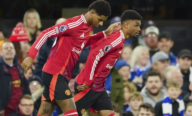 Manchester United's Marcus Rashford, left, is congratulated by Amad Diallo after scoring his side's opening goal during the English Premier League soccer match between Ipswich Town and Manchester United at Portman Road stadium in Ipswich, England, Sunday, Nov. 24, 2024. (AP Photo/Dave Shopland)