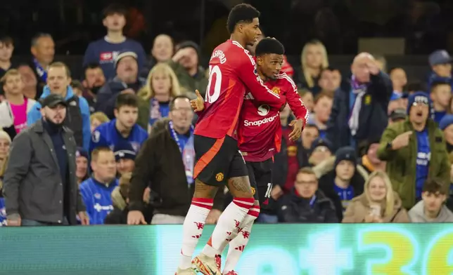 Manchester United's Marcus Rashford, left, is congratulated by Amad Diallo after scoring his side's opening goal during the English Premier League soccer match between Ipswich Town and Manchester United at Portman Road stadium in Ipswich, England, Sunday, Nov. 24, 2024. (AP Photo/Dave Shopland)