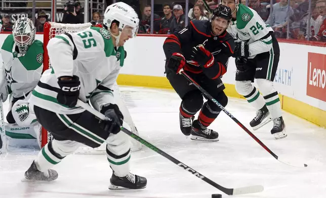 Dallas Stars' Thomas Harley (55) gathers in the puck as Carolina Hurricanes' Jordan Staal (11) looks on during the second period of an NHL hockey game in Raleigh, N.C., Monday, Nov. 25, 2024. (AP Photo/Karl B DeBlaker)