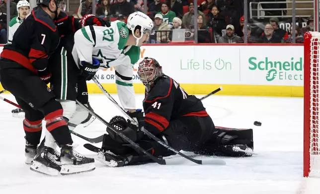 Dallas Stars' Mason Marchment (27) has his shot go wide of the net behind Carolina Hurricanes goaltender Spencer Martin (41) with Hurricanes' Dmitry Orlov (7) nearby during the first period of an NHL hockey game in Raleigh, N.C., Monday, Nov. 25, 2024. (AP Photo/Karl B DeBlaker)