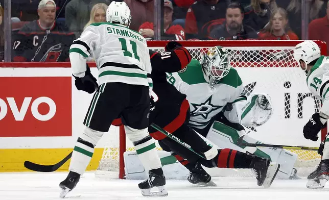 Dallas Stars goaltender Jake Oettinger (29) blocks a shot by Carolina Hurricanes' Jack Drury (18) with Stars' Logan Stankoven (11) nearby during the first period of an NHL hockey game in Raleigh, N.C., Monday, Nov. 25, 2024. (AP Photo/Karl B DeBlaker)