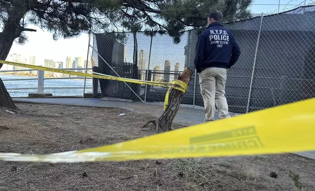 An NYPD officer works at the scene of a stabbing in New York, Monday, Nov. 18, 2024. (AP Photo/David R. Martin)