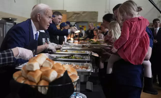 President Joe Biden, left, serves food at a Friendsgiving event with service members and their families in the Staten Island borough of New York, Monday, Nov. 25 2024. (AP Photo/Manuel Balce Ceneta)