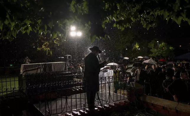 A rabbi delivers an eulogy next to the coffin containing the remains of Israeli-Moldovan rabbi Zvi Kogan in Kfar Chabad, Israel, Monday Nov. 25, 2024. Kogan, 28, an ultra-Orthodox rabbi, was killed last week in Dubai where he ran a kosher grocery store. Israelis have flocked for commerce and tourism since the two countries forged diplomatic ties in the 2020 Abraham Accords.(AP Photo/Ohad Zwigenberg)