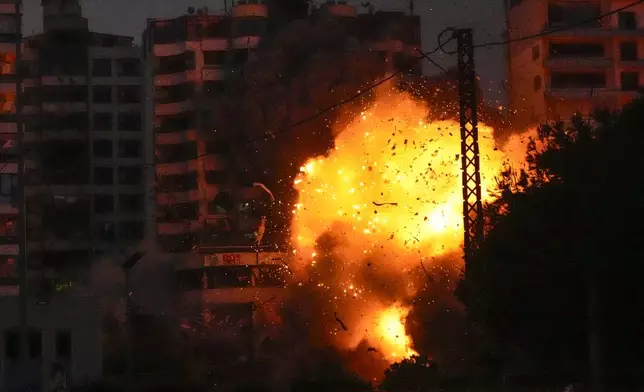 Thick smoke, flames and debris erupt from an Israeli airstrike that targeted a building in Tayouneh, Beirut, Lebanon, Monday, Nov. 25, 2024. (AP Photo/Hassan Ammar)