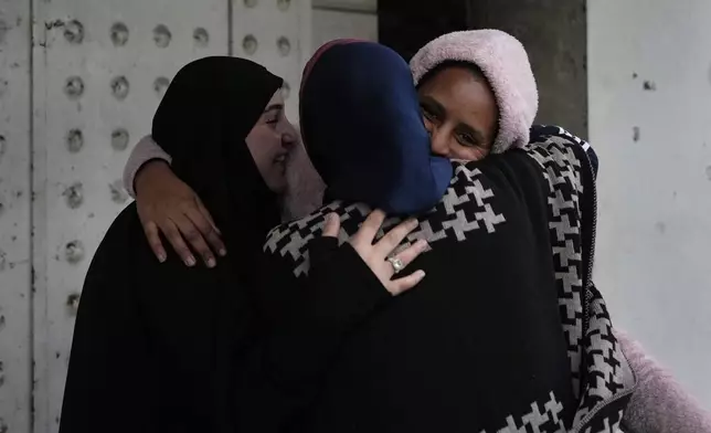 People hug each other upon their arrival at their neighborhood as they celebrate a ceasefire between Hezbollah and Israel, which began early morning, in Tyre, south Lebanon, Wednesday, Nov. 27, 2024. (AP Photo/Hussein Malla)