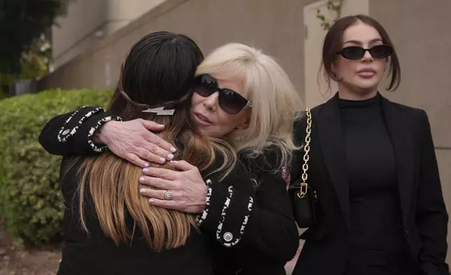 Tammi Menendez, center, the wife of Eric Menendez, is hugged by an unidentified woman as she leaves a courthouse after a hearing in Los Angeles, Monday, Nov. 25, 2024. (AP Photo/Jae C. Hong)