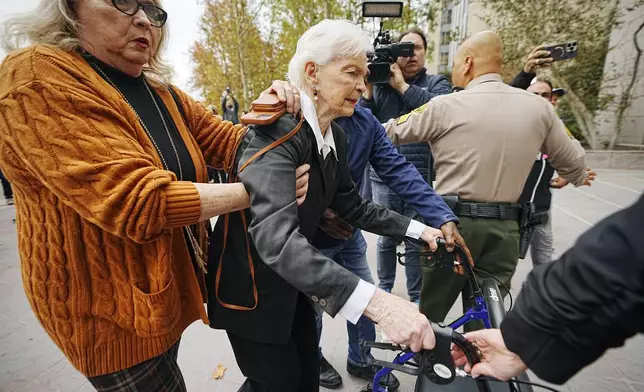 Erik and Lyle Menendez's aunt Joan VanderMolen, center, is assisted by Karen VanderMolen, as they arrive to attend a hearing at the Van Nuys courthouse in Los Angeles, Monday, Nov. 25, 2024. (AP Photo/Damian Dovarganes)