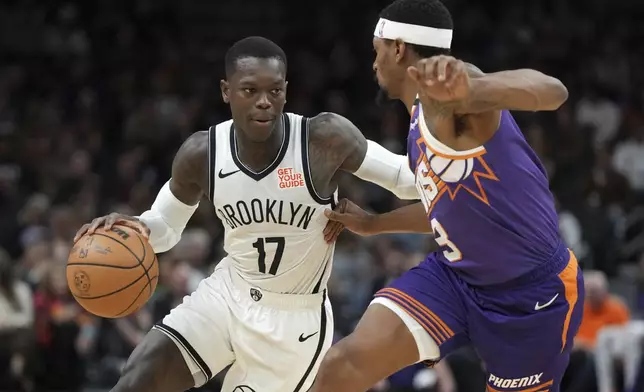 Brooklyn Nets guard Dennis Schroder (17) drives on Phoenix Suns guard Bradley Beal during the first half of an NBA basketball game, Wednesday, Nov. 27, 2024, in Phoenix. (AP Photo/Rick Scuteri)