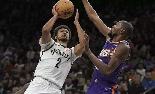 Brooklyn Nets forward Cameron Johnson (2) drives on Phoenix Suns forward Kevin Durant during the first half of an NBA basketball game, Wednesday, Nov. 27, 2024, in Phoenix. (AP Photo/Rick Scuteri)