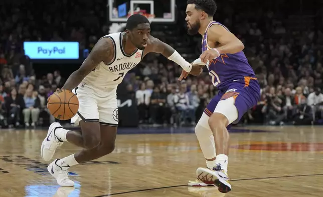 Brooklyn Nets guard Shake Milton (7) drives on Phoenix Suns guard Tyus Jones during the first half of an NBA basketball game, Wednesday, Nov. 27, 2024, in Phoenix. (AP Photo/Rick Scuteri)