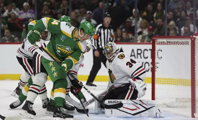 Minnesota Wild center Joel Eriksson Ek (14) attempts to score on Chicago Blackhawks goaltender Petr Mrazek (34) during the first period of an NHL hockey game, Friday, Nov. 29, 2024, in St. Paul, Minn. (AP Photo/Ellen Schmidt)