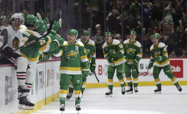 Minnesota Wild defenseman Jared Spurgeon, front right, is congratulated at the bench after scoring during the second period of an NHL hockey game against the Chicago Blackhawks, Friday, Nov. 29, 2024, in St. Paul, Minn. (AP Photo/Ellen Schmidt)