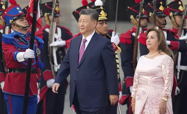 China's President Xi Jinping, center, and Peru's President Dina Boluarte face the honor guard during a welcome ceremony at the government palace in Lima, Peru, Thursday, Nov. 14, 2024, on the sidelines of the Asia-Pacific Economic Cooperation (APEC) summit. (AP Photo/Fernando Vergara)