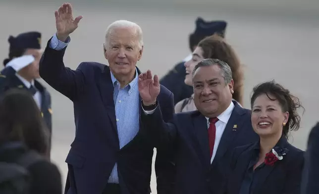 U.S. President Joe Biden, left, Peru's Prime Minister Gustavo Adrianzen, center, and US Ambassador to Peru Stephanie Syptak-Ramnath wave on the airport tarmac ahead of the Asia-Pacific Economic Cooperation (APEC) summit, in Lima, Peru, Thursday, Nov. 14, 2024. (AP Photo/Guadalupe Pardo)