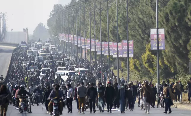 Supporters of imprisoned former premier Imran Khan's Pakistan Tehreek-e-Insaf party move towards D-Chowk square close to Red Zone, which is an area that houses key government buildings, during their rally demanding Khan's release, in Islamabad, Pakistan, Tuesday, Nov. 26, 2024. (AP Photo/W.K. Yousufzai)