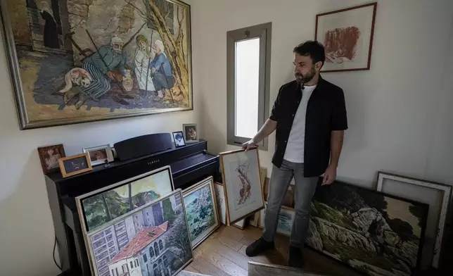 Lubnan Baalbaki shows his father's paintings during an interview with The Associated Press at his house in Geitawi, Beirut, Lebanon, Thursday, Oct. 31, 2024. (AP Photo/Bilal Hussein)