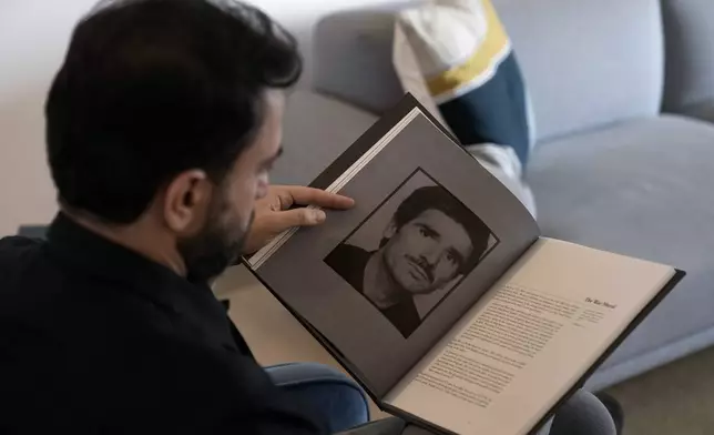 Lubnan Baalbaki shows a picture of his late father during an interview with The Associated Press at his house in Geitawi, Beirut, Lebanon, Thursday, Oct. 31, 2024. (AP Photo/Bilal Hussein)