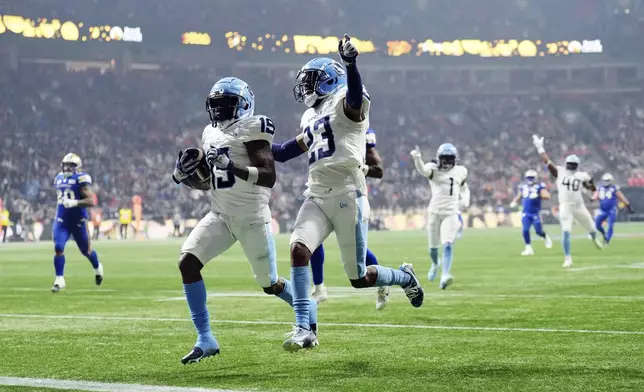 Toronto Argonauts' Robert Priester (19) scores a touchdown after an interception against the Winnipeg Blue Bombers with Benjie Franklin (23) during the second half of a CFL football game at the 111th Grey Cup in Vancouver, British Columbia, Sunday, Nov. 17, 2024. (Nathan Denette/The Canadian Press via AP)