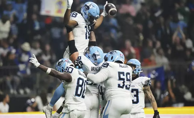 Toronto Argonauts' Dejon Brissett (18) celebrates his touchdown against the Winnipeg Blue Bombers with teammates during the second half of a CFL football game at the 111th Grey Cup in Vancouver, British Columbia, Sunday, Nov. 17, 2024. (Nathan Denette/The Canadian Press via AP)