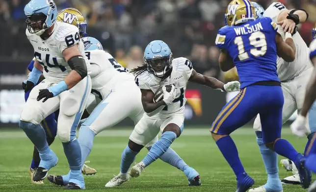 Toronto Argonauts' Deonta McMahon (24) runs against the Winnipeg Blue Bombers during the second half of a CFL football game at the 111th Grey Cup in Vancouver, British Columbia, Sunday, Nov. 17, 2024. (Nathan Denette/The Canadian Press via AP)