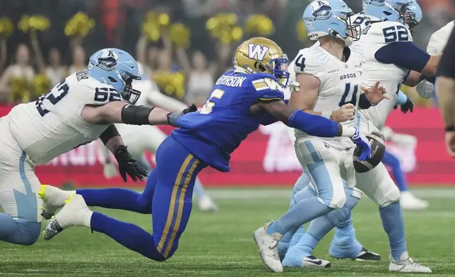 Winnipeg Blue Bombers' Willie Jefferson (5) strips the ball from Toronto Argonauts quarterback Nick Arbuckle (4) during the the second half of a CFL football game at the 111th Grey Cup in Vancouver, British Columbia, Sunday, Nov. 17, 2024. (Nathan Denette/The Canadian Press via AP)