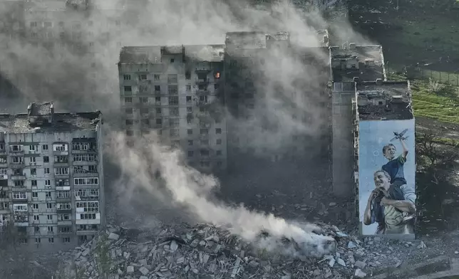 FILE - Smoke rises from a building in Bakhmut, the site of the heaviest battles with the Russian troops in the Donetsk region, Ukraine, Wednesday, April 26, 2023. (AP Photo/Libkos, File)