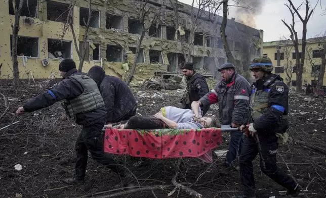 FILE - Ukrainian emergency employees and volunteers carry an injured pregnant woman from a maternity hospital damaged by shelling in Mariupol, Ukraine, Wednesday, March 9, 2022. (AP Photo/Evgeniy Maloletka, File)