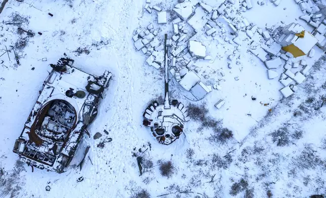 FILE - A destroyed Russian tank, covered in snow, stands in the yard of a private house in the town of Sviatohirsk, Ukraine, Sunday, Feb. 12, 2023. (AP Photo/Evgeniy Maloletka, File)