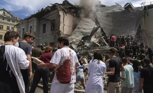 FILE - Rescuers, volunteers and medical workers clean up the rubble and search for victims after a Russian missile hit the country's main children's hospital Okhmadit, in Kyiv, Ukraine, Monday, July 8, 2024. (AP Photo/Efrem Lukatsky, File)