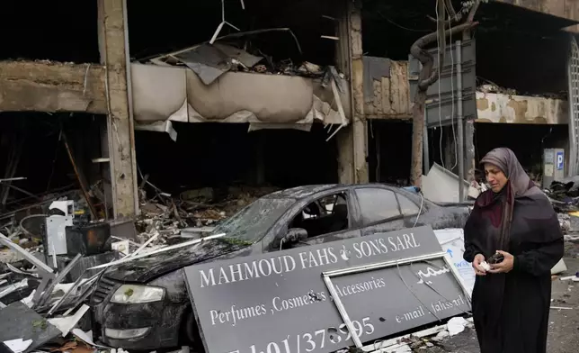 A woman weeps as she passes in front of destroyed shops that were hit Sunday evening in an Israeli airstrike in central Beirut, Lebanon, Monday, Nov. 18, 2024. (AP Photo/Hussein Malla)