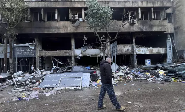 A Lebanese policeman walks in front of destroyed shops that were hit Sunday evening by an Israeli airstrike in central Beirut, Lebanon, Monday, Nov. 18, 2024. (AP Photo/Hussein Malla)