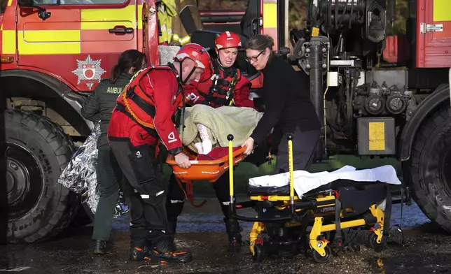 A local resident, wrapped in blankets, is attended to as she is lifted into an emergency vehicle at the Billing Aquadrome in Northamptonshire, England, Monday Nov. 25, 2024, after Storm Bert caused "devastating" flooding over the weekend. (Jordan Pettitt/PA via AP)