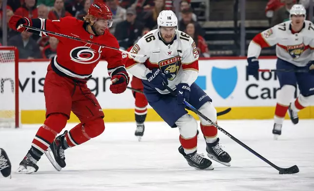 Florida Panthers' Aleksander Barkov (16) is challenged by Carolina Hurricanes' Jordan Staal, left, during the first period of an NHL hockey game in Raleigh, N.C., Friday, Nov. 29, 2024. (AP Photo/Karl B DeBlaker)