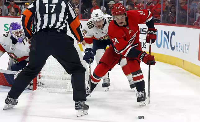 Carolina Hurricanes' Seth Jarvis (24) controls the puck in front of Florida Panthers' Nate Schmidt (88) during the second period of an NHL hockey game in Raleigh, N.C., Friday, Nov. 29, 2024. (AP Photo/Karl B DeBlaker)