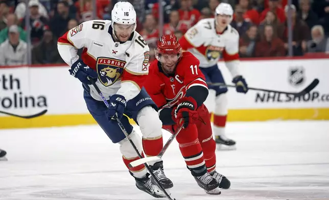 Florida Panthers' Aleksander Barkov (16) is challenged by Carolina Hurricanes' Jordan Staal (11) during the first period of an NHL hockey game in Raleigh, N.C., Friday, Nov. 29, 2024. (AP Photo/Karl B DeBlaker)