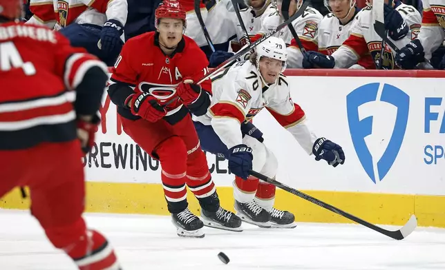 Carolina Hurricanes' Sebastian Aho (20) clears the puck away from Florida Panthers' Jesper Boqvist (70) during the first period of an NHL hockey game in Raleigh, N.C., Friday, Nov. 29, 2024. (AP Photo/Karl B DeBlaker)