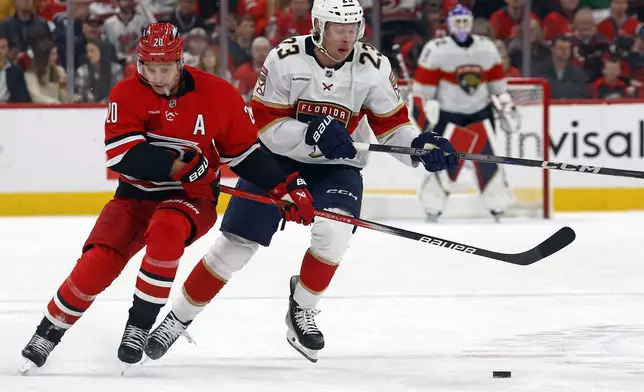 Florida Panthers' Carter Verhaeghe (23) collides with Sebastian Aho (20) during the first period of an NHL hockey game in Raleigh, N.C., Friday, Nov. 29, 2024. (AP Photo/Karl B DeBlaker)